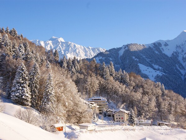 Ett snötäckt berglandskap med ett hotell och andra byggnader i förgrunden.