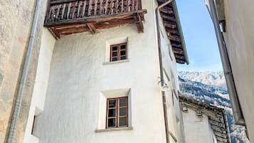 Ein Gebäude mit einem traditionellen Holzbalkon und zwei Fenstern.