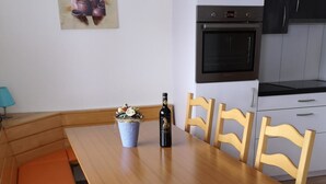 Een eethoek met een houten tafel, banken en stoelen.