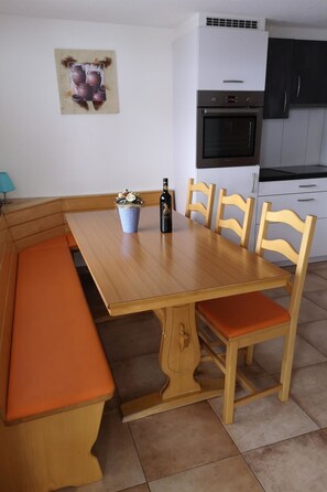A dining area with a wooden table, benches, and chairs. - Chalet Bambi by Interhome (Saas-Fee)