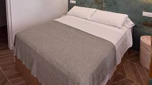 Ein modernes Schlafzimmer mit einem Bett, einer strukturierten Wand und einem kleinen Nachttisch.