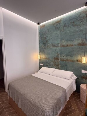 Ein modernes Schlafzimmer mit einem Bett, einer strukturierten Wand und einem kleinen Nachttisch.