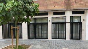 Ein Gebäude mit modernem Design, mit einer gefliesten Erdgeschossfassade und einem Obergeschoss aus Backstein.