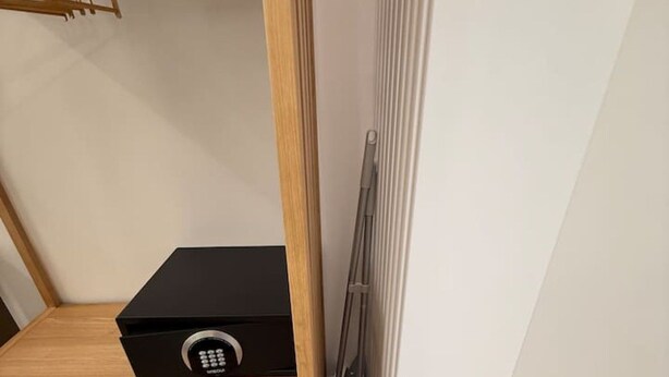 Eine Raumecke mit einem Holzregal, einem schwarzen elektronischen Gerät und einer Heizung.