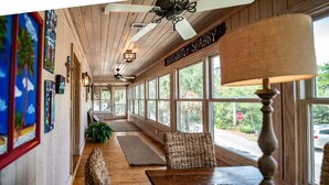 A long, narrow room with wooden floors, a bench, and a table with a lamp. - 4BR Beach House w/ Covered Porches, Game Room & Shared Creek Dock Access (Pawleys Island)