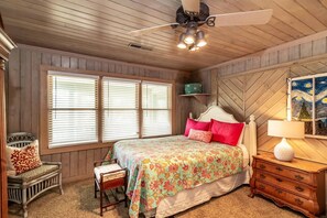A bedroom with a bed, a chair, a dresser, a ceiling fan, and a painting on the wall. - 4BR Beach House w/ Covered Porches, Game Room & Shared Creek Dock Access (Pawleys Island)