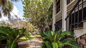 A pathway leading to a building with a brick wall and a window. - 4BR Beach House w/ Covered Porches, Game Room & Shared Creek Dock Access (Pawleys Island)