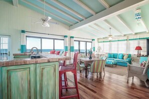 Uma sala de estar ampla com uma mesa de jantar, cadeiras e um sofá.