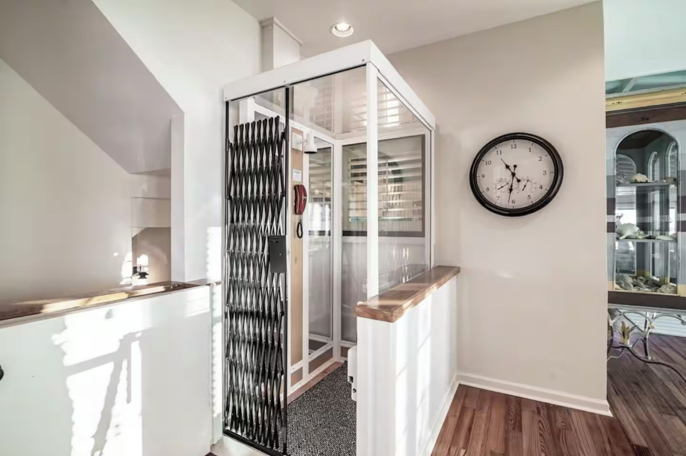 A modern kitchen with a wooden countertop, a white cabinet, and a glass partition.