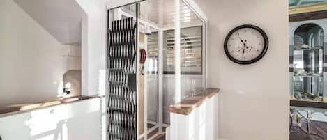 A modern kitchen with a wooden countertop, a white cabinet, and a glass partition.