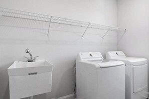 A laundry area with a sink and two washing machines. - New Ocean View Beach Home | 3-Min Walk to Litchfield Beach & Resort Amenities (Pawleys Island)