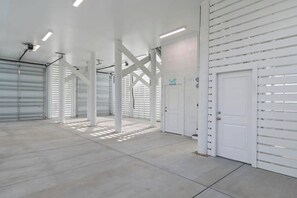 Et rummeligt indre område med hvide vægge og loft, med flere døre og et stort åbent rum.