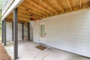 A covered porch with a ceiling fan, a door with a window, and a concrete floor. - Family-Friendly Coastal Retreat Near the Beach w/ Pools, Golf & Bike Trails (Pawleys Island)