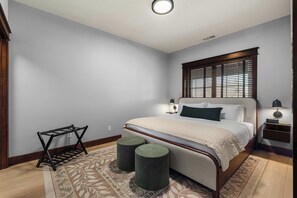 Bedroom with a luggage rack and a wood-framed upholstered bed - Cozy Riverstone Escape | Walkable CDA Location (Coeur d'Alene)