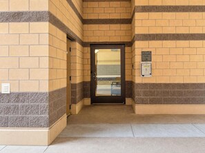 A building entrance with a glass door, a sign indicating a residential lobby, and a security intercom system. - Unwind at Riverstone Loft (Coeur d'Alene)
