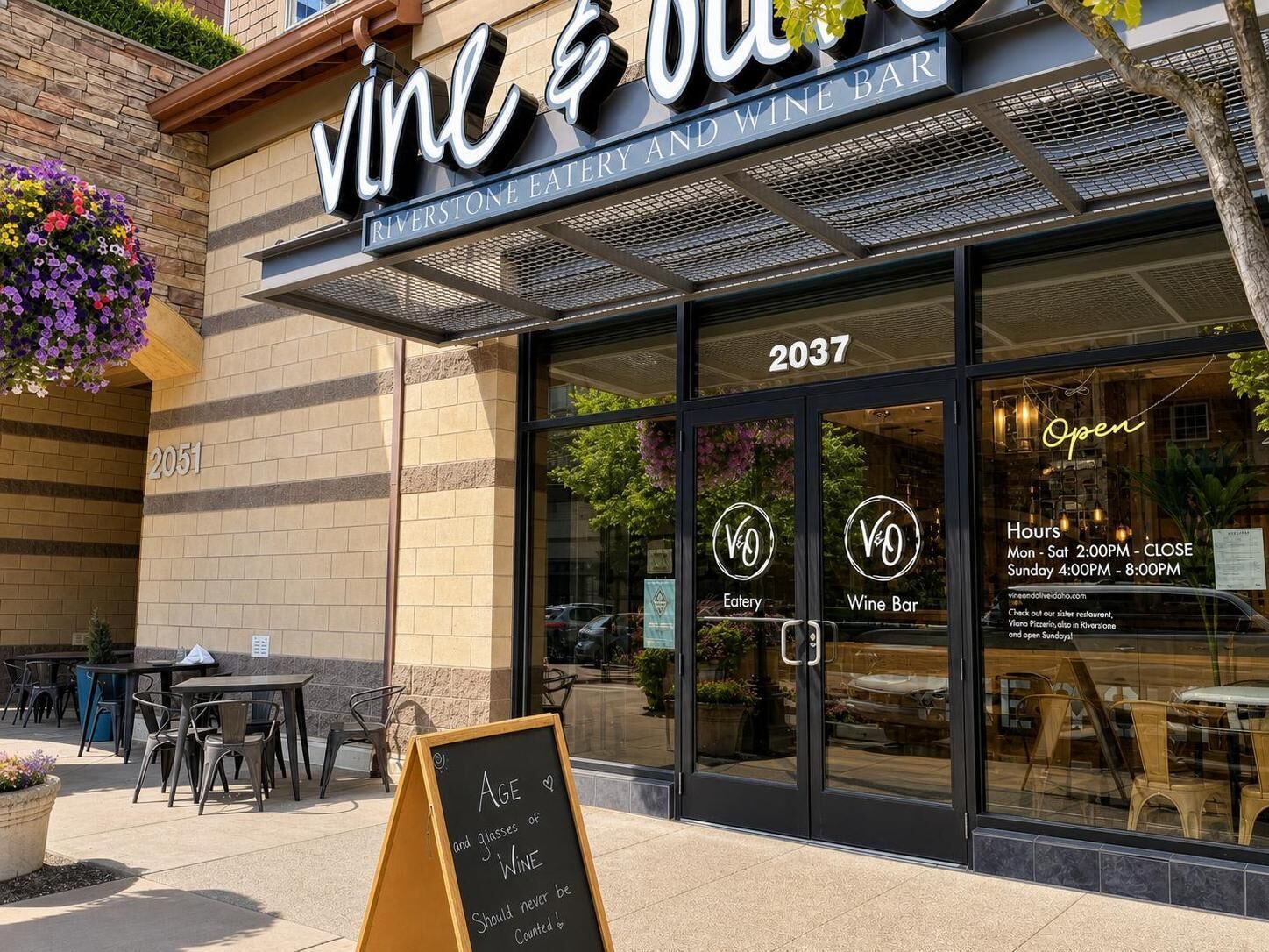 Exterior de un restaurante llamado 'Vino & Wine Bar' con un letrero que indica que es un restaurante Riverstone.