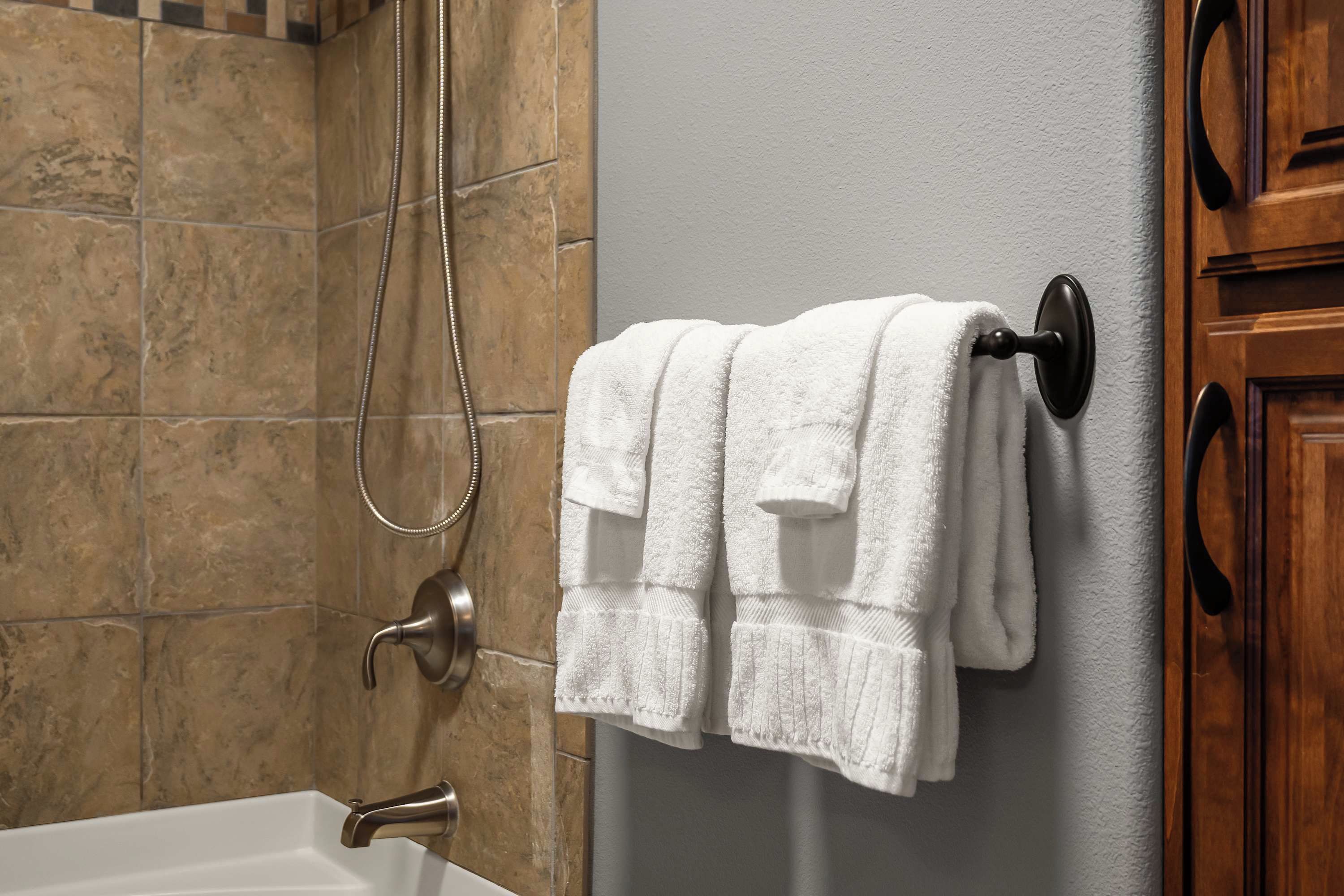 Fresh white towels hung by the tub and shower