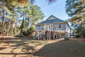 A two-story house with a porch and a staircase leading to the entrance. - 4BR Beach Retreat Just Minutes from North Litchfield's Sandy Shore (Pawleys Island)