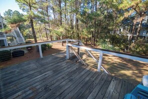 A wooden deck with railings, surrounded by trees and a building with a staircase. - Beach House Near North Litchfield w/ Spacious Living Areas & Outdoor Deck (Pawleys Island)