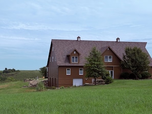 Ein zweigeschossiges Haus mit geneigtem Dach, einer Garage und einem gepflegten Rasen.
