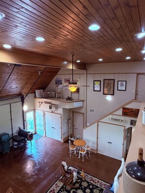 Un loft espacioso con techos altos, un comedor con candelabro y vistas al exterior.
