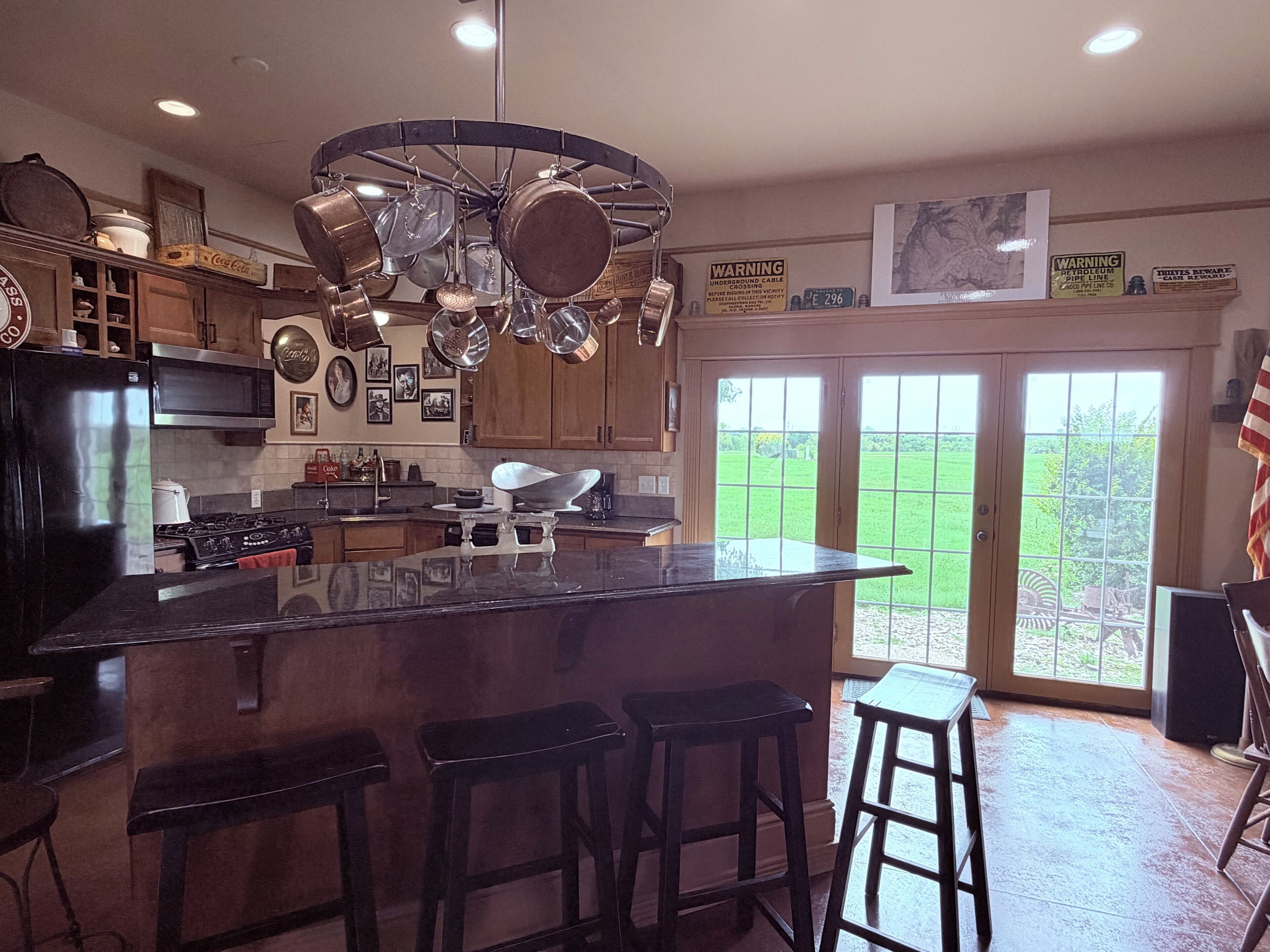 A kitchen with a central island, bar stools, and an American flag.