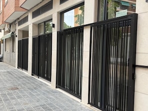 Ein Gebäude mit einer modernen Fassade, einem verschlossenen Eingang und einem mit Fliesen belegten Weg.