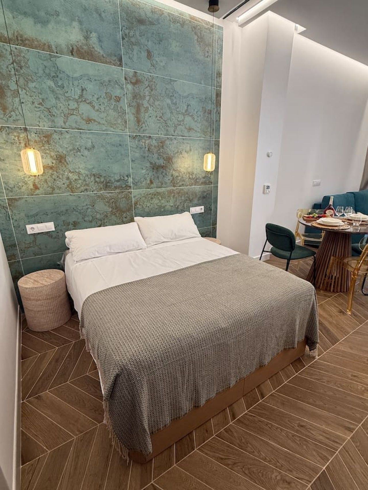 Ein modernes Schlafzimmer mit einem großen Bett, einem runden Nachttisch und einem Essbereich mit Tisch und Stühlen.