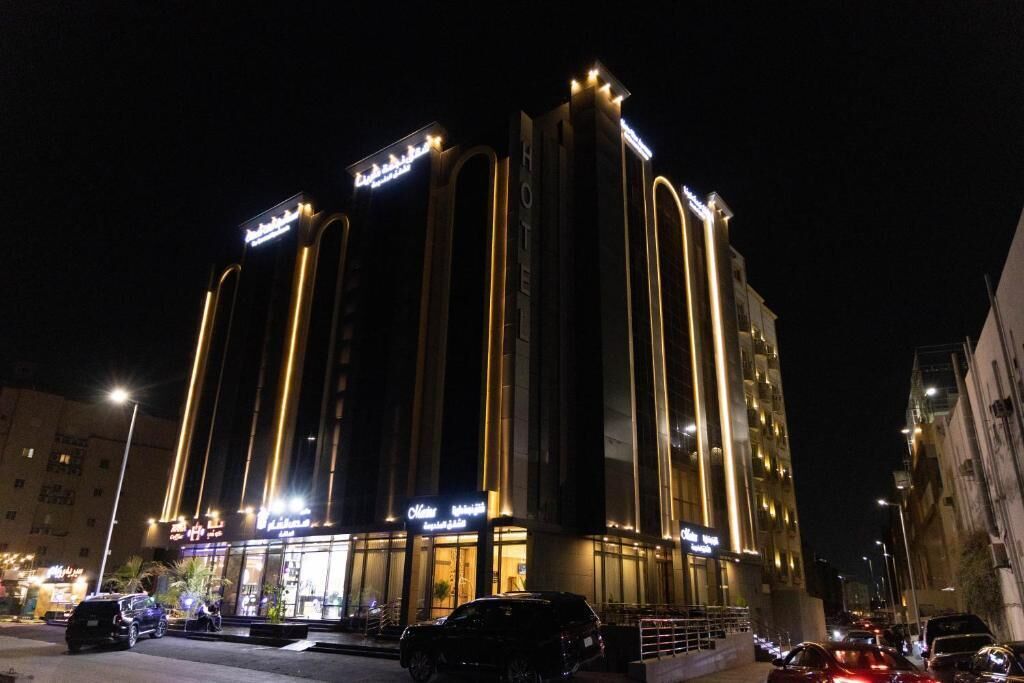 A multi-story hotel with illuminated signage and vertical light strips.