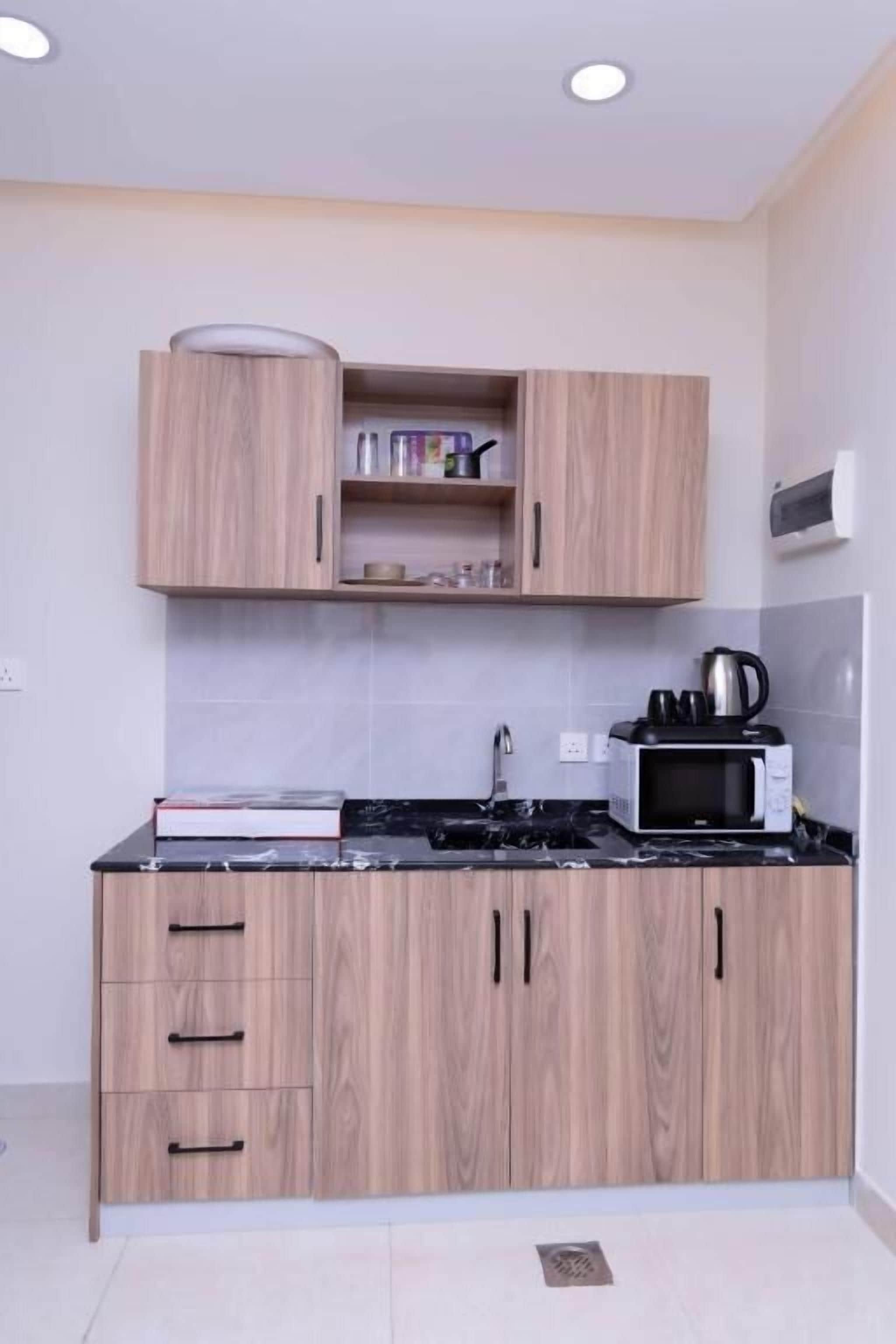 Una cocina moderna con armarios de madera, un microondas y un lavamanos.