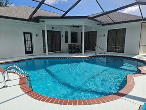 A swimming pool with a brick border, a covered patio area, and a ceiling fan. -  4-br 3-ba Beautiful Suncoast Pool House centrally located in Lecanto Fl. (Lecanto)