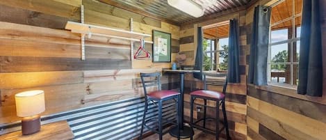 A wooden interior with a bar area, chairs, and a table.