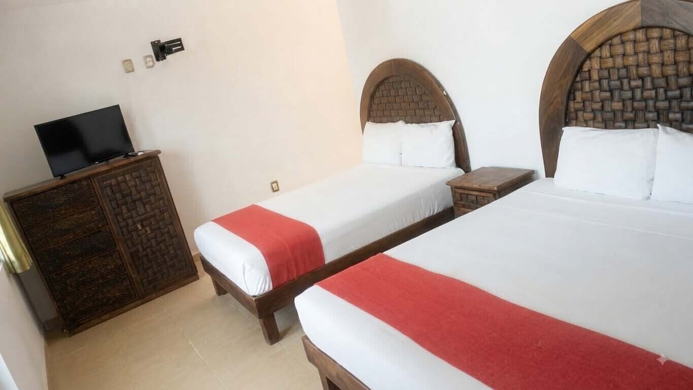 A hotel room with two beds, a TV on a cabinet, and a small table.