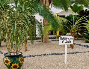 Un jardín con un cartel que dice 'Prohibido el paso al Jardín', indicando que no se permite el acceso.