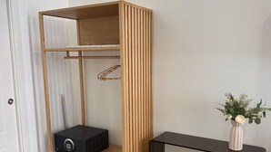 Ein Zimmer mit einem Holzschrank, einem schwarzen Konsolentisch und einer Vase mit Blumen.