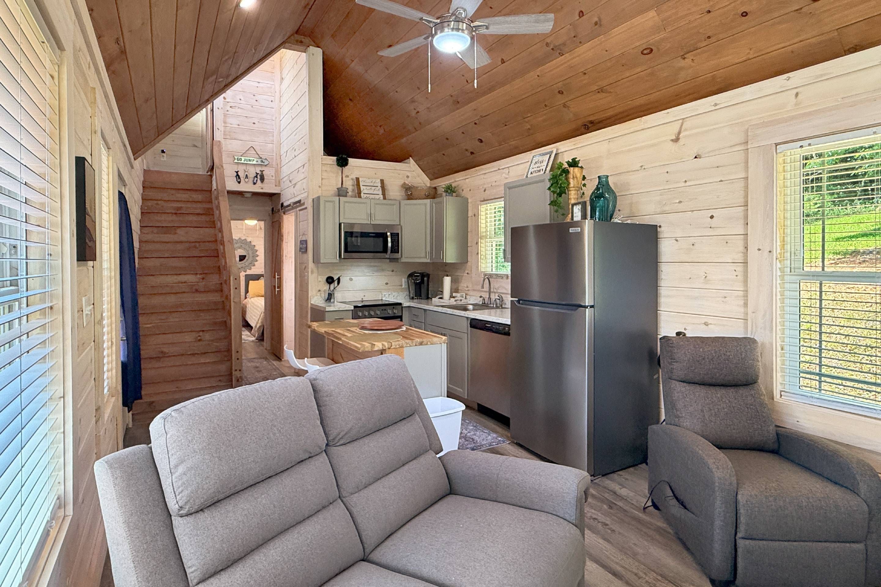 A modern kitchen with a stainless steel refrigerator, wooden cabinets, and a microwave.