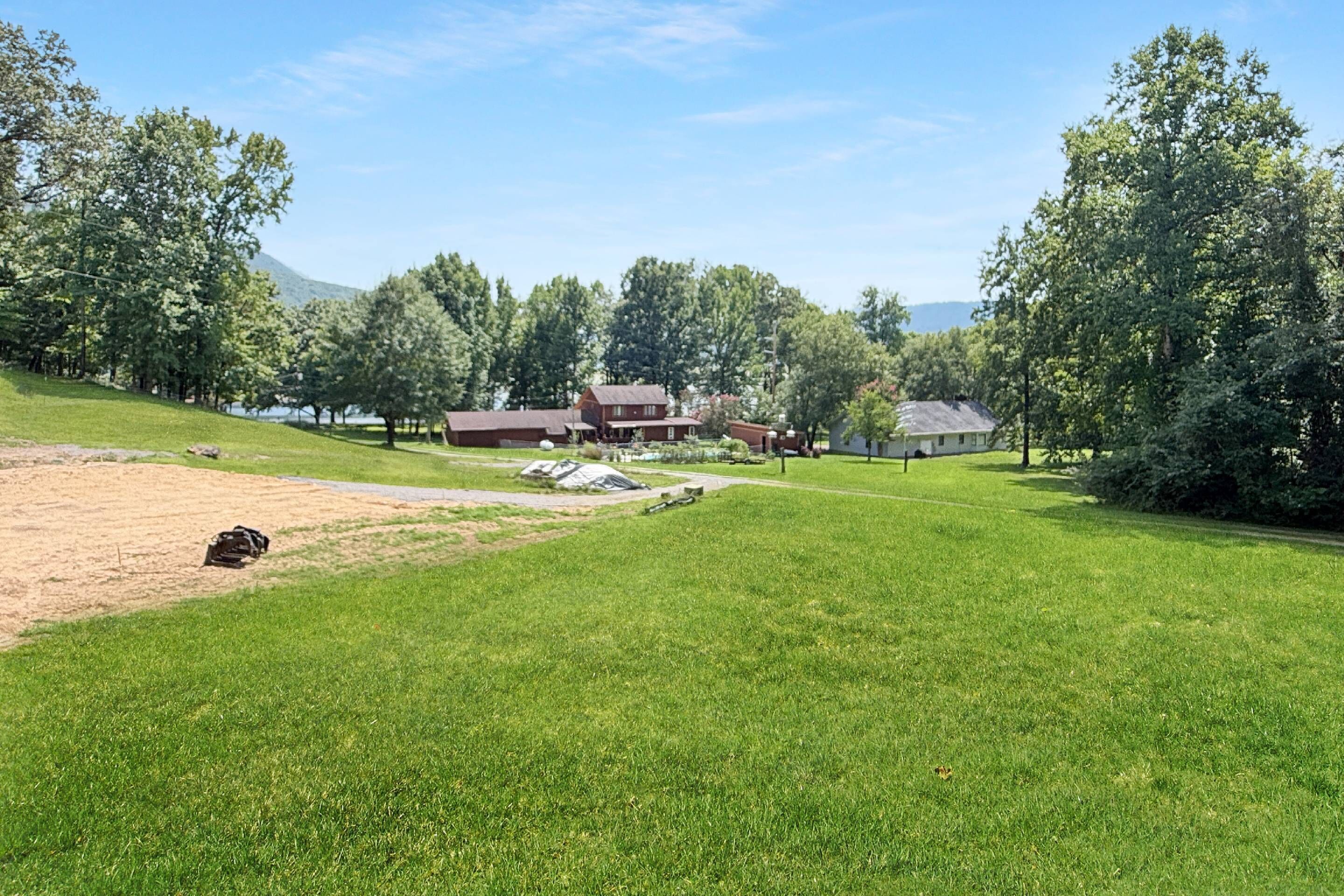 A residential area with a large house, a smaller building, and a well-maintained lawn.