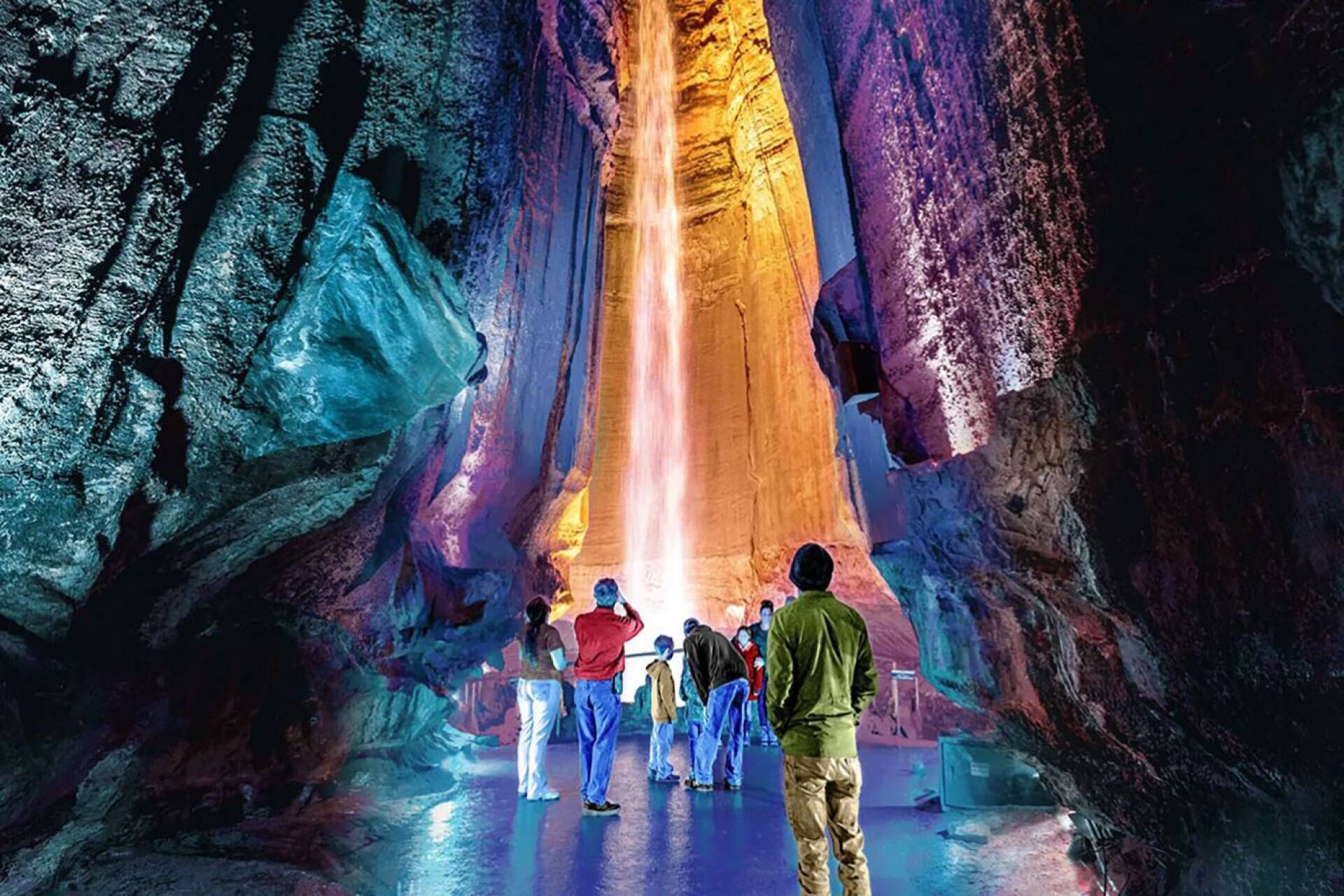 Eine Gruppe von Menschen in einer Höhle mit einem Wasserfall.