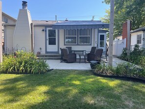 Une propriété résidentielle dotée d’un patio couvert, d’un espace salon extérieur et d’un jardin.