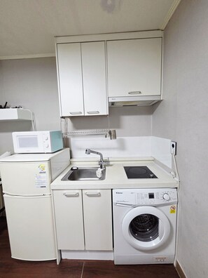 A compact kitchenette with a microwave, sink, and washing machine. - Annie Stay Chungmuro Near Myeongdong & Namsan Your Cozy Home in Central Seoul (중구)