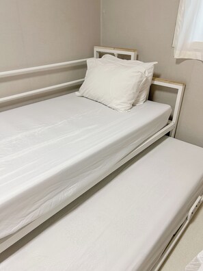 A single-bed room with a wooden headboard, white bedding, and a plain wall. - Annie Stay Chungmuro Near Myeongdong & Namsan Your Cozy Home in Central Seoul (중구)