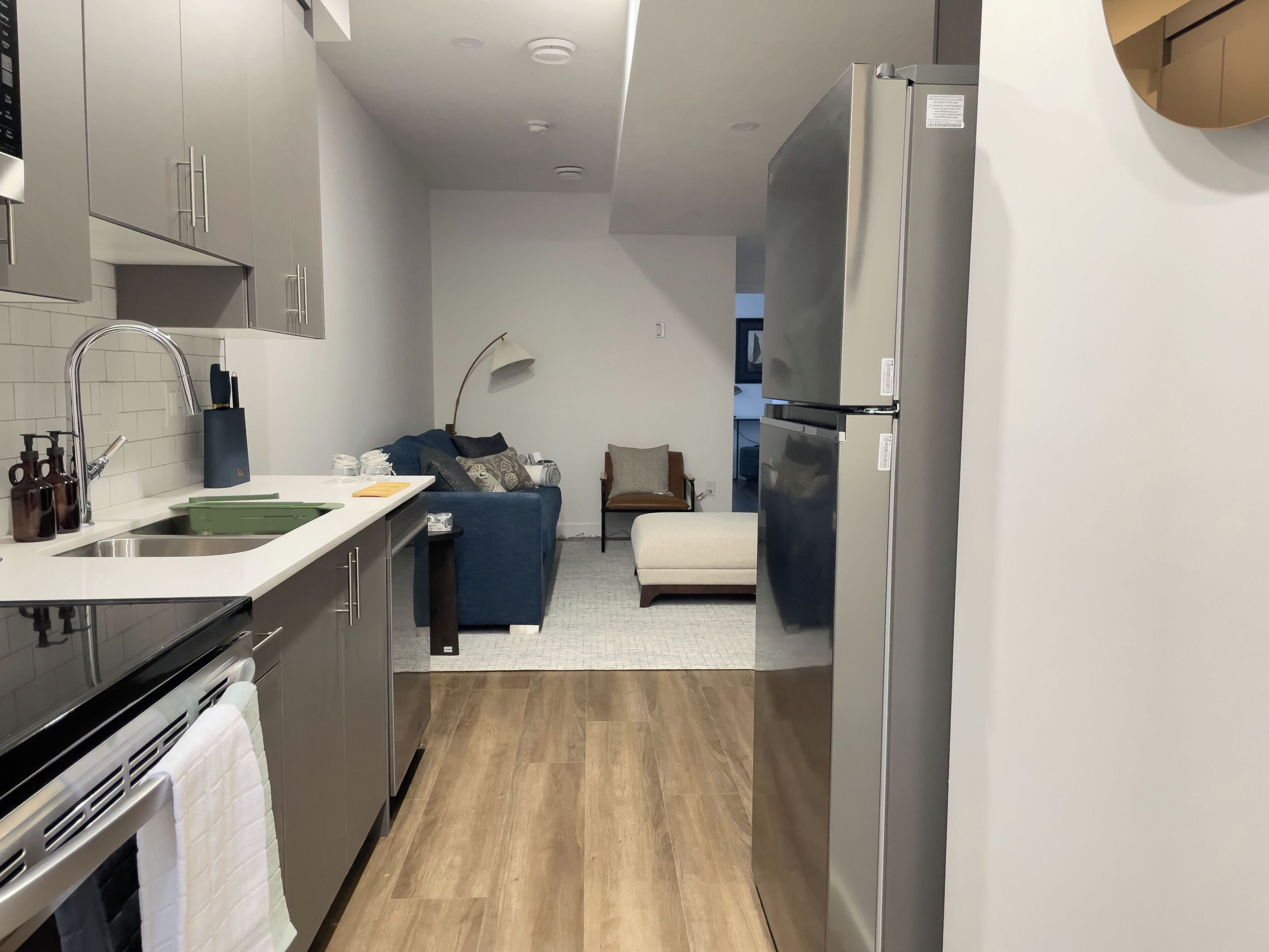 Una cocina compacta con horno integrado, fregadero y refrigerador.