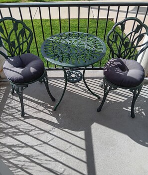 A round metal table with a patterned top, flanked by two chairs with cushioned seats. - Comfy 1 Bedroom Apartment! Salt Lake City. Close to UofU (Salt Lake City)