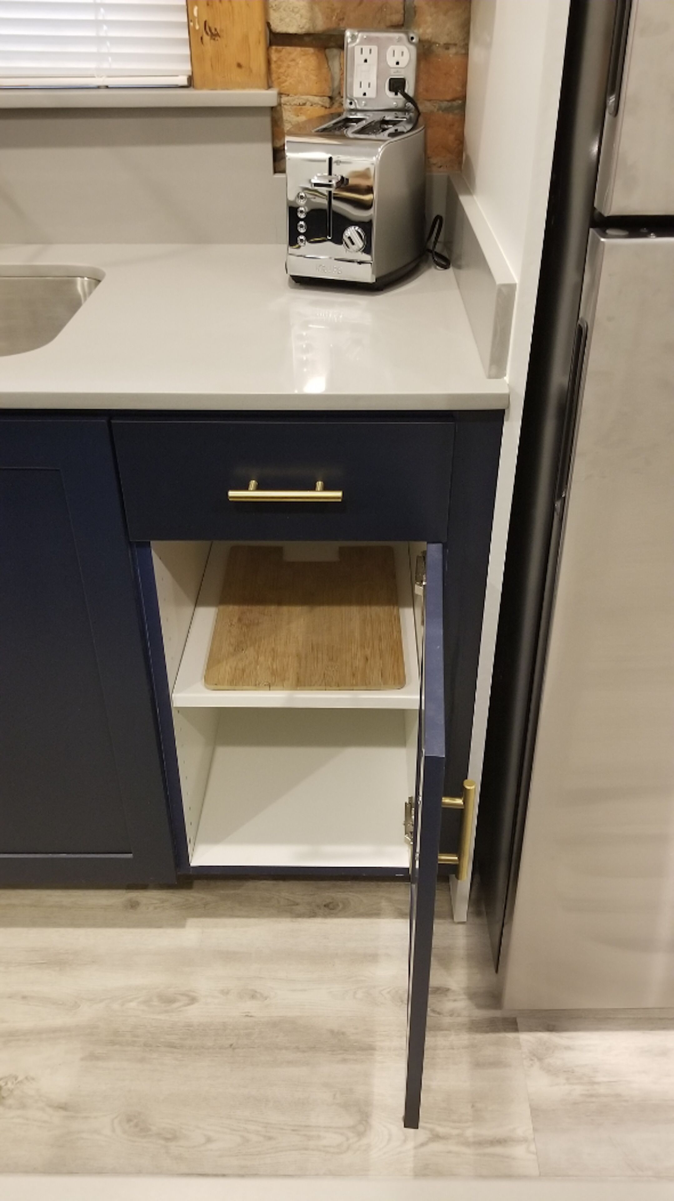 Una cocina con encimera, un tostador y un refrigerador.