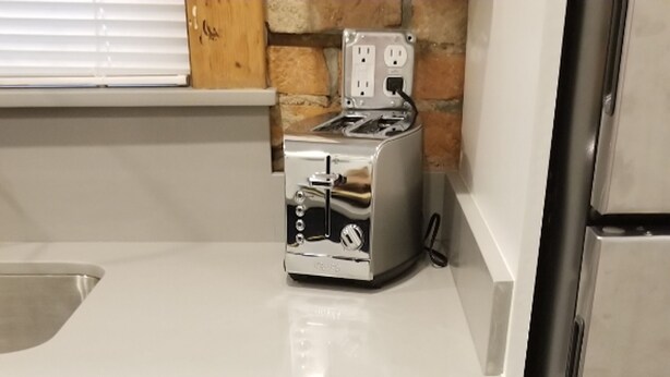 Una cocina con encimera, un tostador y un refrigerador.
