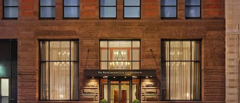 A brick building with large windows and a sign reading "The Ritz-Carlton Club and Residences."