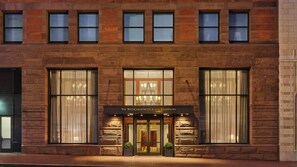 Un bâtiment en briques doté de grandes fenêtres et d’une enseigne indiquant : « The Ritz-Carlton Club and Residences ».