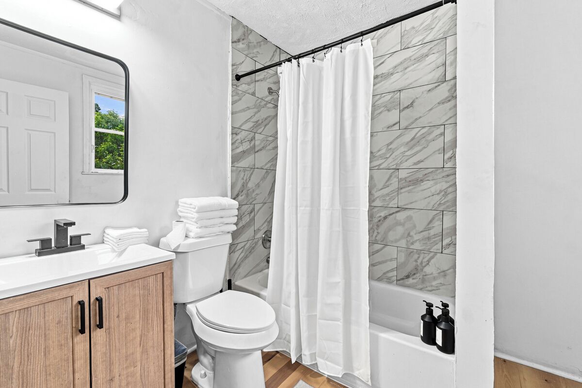 A bathroom with a toilet, sink, and bathtub.