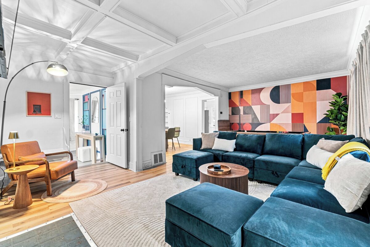 A modern living room with a sectional sofa, a coffee table, and a lamp.