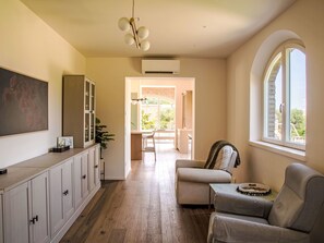 A spacious living area with a sofa, a dining table, and a kitchen in the background. - Tenuta Marino – con piscina privata by Interhome (Cesano)